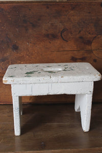 Small wooden stool in chippy white paint